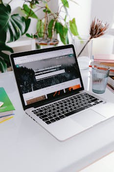 A stylish home office setup featuring a laptop on a desk surrounded by plants, capturing a calm work-from-home vibe.